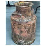 A rusted milk can
