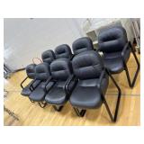 Eight black cushioned chairs
