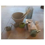 Large plastic pot, watering cans and mulch