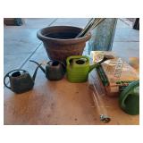 Large plastic pot, watering cans and mulch