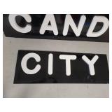 Black Background White Lettering Candy City Signs
