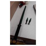 black and green sword with two throwing knives