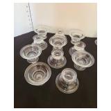 Eleven invertible candle holders for tapers and votives and two others