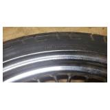 Used Bridgestone Spitfire 11F 90/90/19 52H Front Motorcycle Tire mounted on a spoked chrome rim