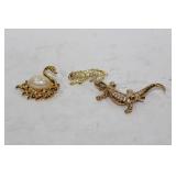 Three gold colored decorative brooches