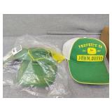 Two John Deere hats one is sealed in plastic