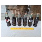 Six Unopened Coke Bottles