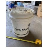 Rural King bucket full of  grass seed.