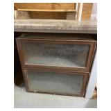 Steel cabinet with flip up glass doors.