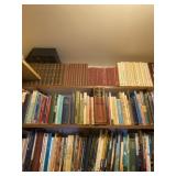 Three shelves of books including bibles and