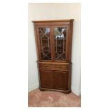 Corner china cabinet with full drawer.