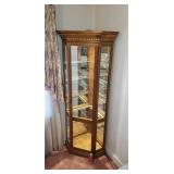 Oak corner curio cabinet lighted with glass