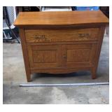 Oak washstand cabinet features a prominent top
