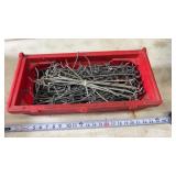 Container full of galvanized metal pegboard hooks