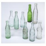 9 NC Green Glass Straight Side Embossed Bottles