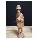 Carved Wooden Man Carrying Backpack In Bare Feet