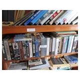 Contents of bookcase: VHS movies, novels