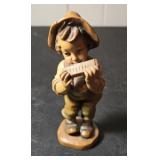 Boy playing harmonica figurine
