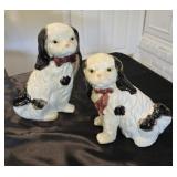 A pair of vintage black and white dogs, one has a