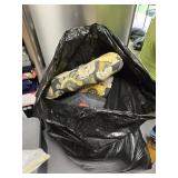 Trash bag full of miscellaneous chair cushions