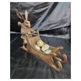 Rabbit pushing a sled with eggs.
