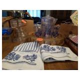 PLASTIC PITCHER-GLASSES, HAND TOWELS ON A WOODEN