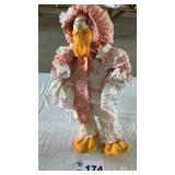 MOTHER GOOSE SITTING IN WICKER CHAIR
