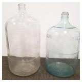 2 large glass water bottles - one marked 5 gallon