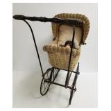 Antique wicker doll buggy with modern doll