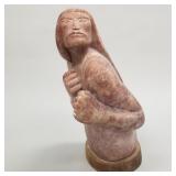 Carved stone Native American figure on wooden