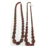 2- 24" strands of amber (?) bead necklaces