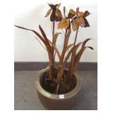 Metal flower sculpture in a pottery planter