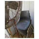 Standing Fan and Black Plastic Chairs