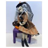 Halloween folk art witch sitting on a bench...