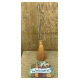 Wooden welcome sign and decorative broom