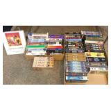 2-boxes of VHS movies under table.