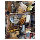 Contents on top of desk fan, drain snake, light, misc