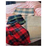 2 plaid blankets, blue and white rug, blue and white throw blanket, ironing board