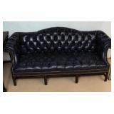 A BUTTON TUCKED CAMEL BACK SOFA WITH BRASS TACKS
