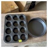 Two non-stick baking pans including cupcake and pi