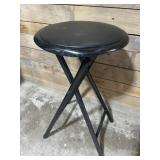 Black folding stool with cushioned top