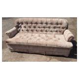 sofa featuring rolled arms, deep button tufting,
