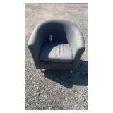 Gray upholstered tub chair with curved back and