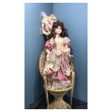 Porcelain doll and wicker chair