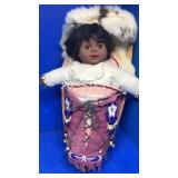 Indian doll in wood bed