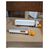 2 metal yellow semi truck and trailer