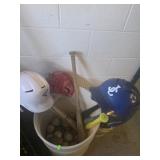 Barrel full of baseballs, bats and helmets