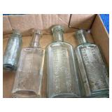 Various Glass Bottles Featuring Embossed and Label