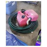Large hose and 2 red gas containers with pour