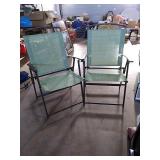 2 green folding patio/lawn chairs.